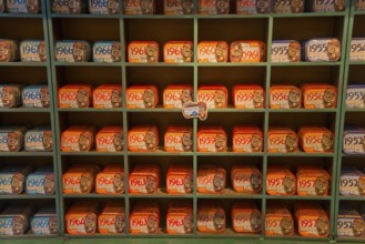 Shelves filled with a variety of colourful and artistically designed sardine tins that have a