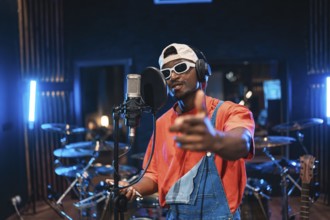 Talented musician recording vocals, pointing at you, wearing trendy sunglasses and cap, creating