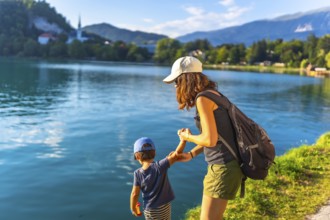 Mother and son holding hands, enjoying summer vacation at lake bled in the julian alps, slovenia