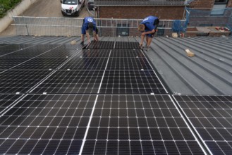 Installation of solar modules on the roof of a barn on a farm, over 240 photovoltaic modules are