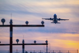 Runway lighting, approach aids, at Düsseldorf International Airport, sunset, aircraft taking off