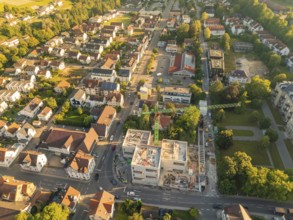 Aerial view of an urban area with an active construction site and many surrounding buildings,