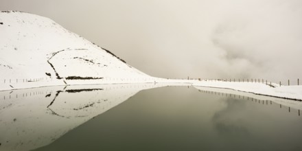 Onset of winter in May, Riezler Alpsee, an artificial lake, snow pond, feeds the snow cannons that