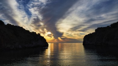 Sunrise with a view through a bay between cliffs and clouds, Mani Peninsula, Peloponnese, Greece,
