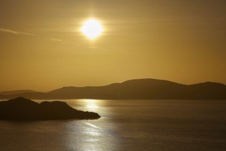 Silent sunset over the sea, golden reflection and silhouetted islands, Makri Island, Alimia Island,