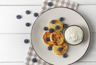 Cottage cheese pancakes, with blueberries, breakfast, on a white wooden table, no people, top view