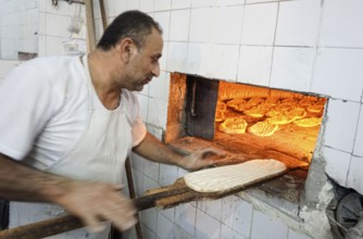 A baker puts the bread in the oven, Barbol, Iran, 18/05/2016, Asia