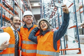 Happy warehouse workers and manager taking a selfie in a logistics center, celebrating success and