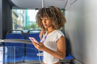 Side view of a beauty young latin woman listening to music standing inside an urban bus