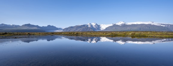 Reflection in a lake, view of Svínafellskökull glacier tongue, glaciated mountain peak