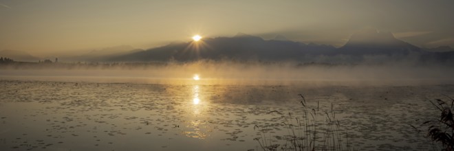 Sunrise at Lake Hopfensee near Füssen, behind Hopfen am See, the Tegelberg massif and the Säuling,