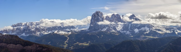 Snow-covered mountains of the Sella Group Mountain landscape under blue sky and clouds, a wide
