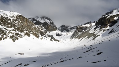 High mountain valley with mountain peak Piz Calderas in winter, view at the Chamanna Jenatsch in