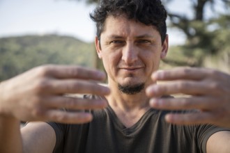 Close-up of a Caucasian adult man practicing the static posture of Tree Hugging, an essential