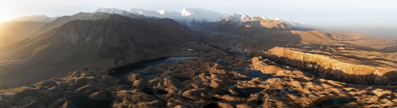Panorama, White glaciated and snow-covered mountain peak Pik Lenin at sunrise, hilly landscape with