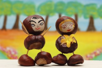 Two cute chestnut figures in front of a painted background, North Rhine-Westphalia, Germany, Europe