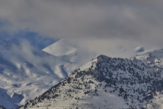 Snow-covered mountain range under a cloudy sky, Lefka Ori, White Mountains, mountain massif, west,