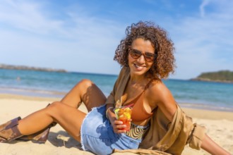 Happy sensual woman sitting on sandy beach enjoying tropical fruit sliced inside a plastic take