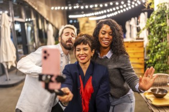 Diverse friends dancing recording tik tok video with smartphone at night party