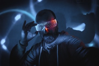 Bearded man adjusting futuristic glowing smart glasses in dark cyberpunk setting with blue and