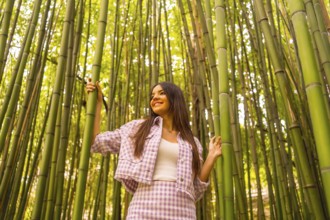 Young caucasian girl with a pink skirt in a bamboo forest. Enjoying the summer holidays in a