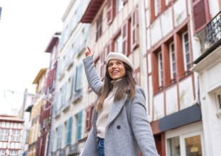 Young beauty stylish woman with warm clothes and beret enjoying in the city