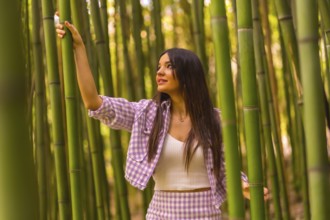 Young caucasian girl with a pink skirt in a bamboo forest. Enjoying summer holidays in a tropical