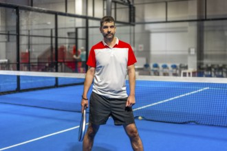Portrait of a sportive mature adult caucasian man in a paddle tennis court
