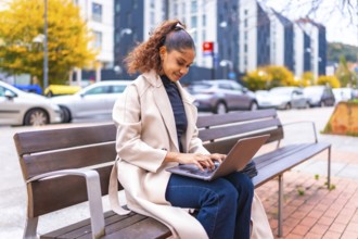Side view photo with copy space of a beauty elegant african woman sitting on a city bench using