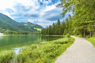Emerald green waters reflecting the surrounding mountains and lush vegetation, creating a