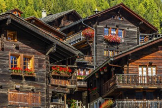 Old wooden houses decorated with flowers in the historic village centre, Grimentz, Val d'Anniviers,