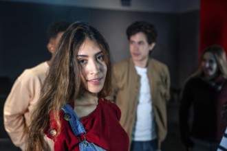 Group of young people enjoying a movie disco dance and event, with a smiling young woman in the