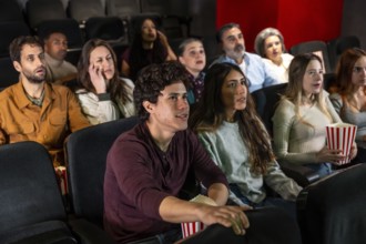 Captivated audience members of various ages and ethnicities experience a thrilling movie screening