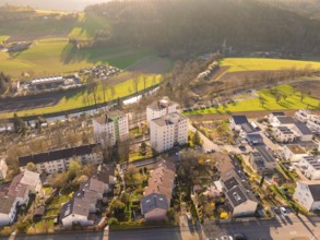 Aerial view of a residential area with river and fields in a rural area in the morning light,