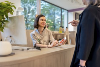 Young cheerful and beauty saleswoman talking to a client in a pharmacy counter