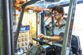 Caucasian adult woman driving a forklift in a warehouse
