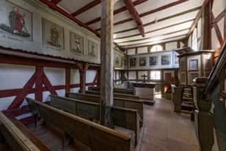 Historic half-timbered church, interior with wooden benches, altar and pulpit, church from