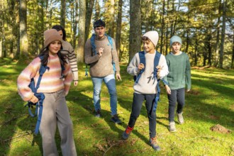Caucasian family with three child enjoying hiking together in the forest