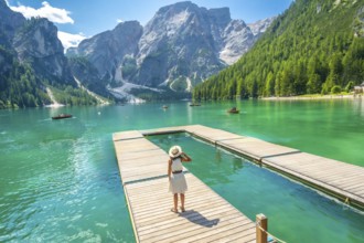 Tourist admiring the breathtaking landscape of lake braies, with its crystal clear turquoise waters