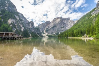 Crystal clear waters reflecting majestic peaks and lush forests create a breathtaking panorama at