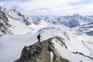 Mountain panorama with view of peaks of the Bernina group, mountaineer descending Piz Grialetsch in