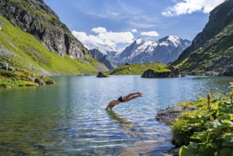 Man taking a header, cooling off while swimming in the mountain lake Lac de Louvie, behind the