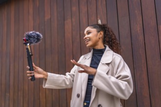 African american beauty woman vlogger talking to her audience streaming online next to wooden city