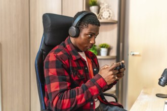 Young man engaging in video gaming and streaming online, wearing headphones and skillfully