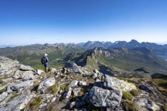 View of mountain landscape, mountain panorama, mountaineer at the summit of Rundfjellet, lake