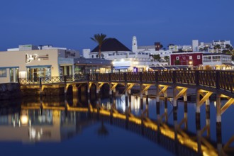 Marina Rubicon marina with illuminated bridge and reflections in the water, Playa Blanca,