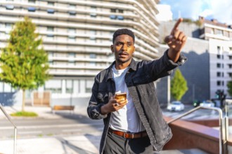African man pointing to a direction using gps mobile app in the city
