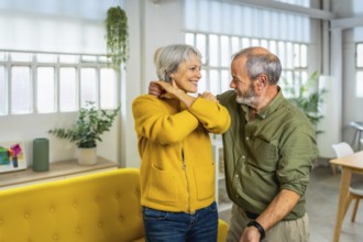 Senior happy modern couple dancing tango together at home