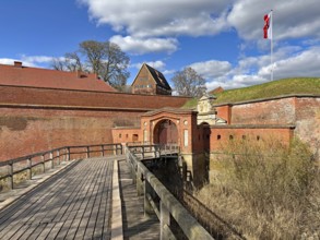 Historic brick fortress with bridge and flag under a blue sky with clouds, Fortress, Dömitz,