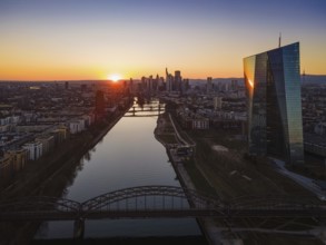 The sun sets behind the European Central Bank (ECB) and the Frankfurt skyline. (Aerial view with a
